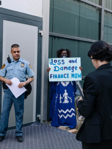 Campaigners hold up placards during the Loss and Damage negotiations that take place at COP 27.